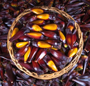 Tahta arka planda kırmızı ve siyah mısır sepeti.