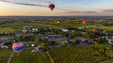 Ağaçların üzerinde süzülen renkli balonlar sabah sisli manzaraya hükmediyor..