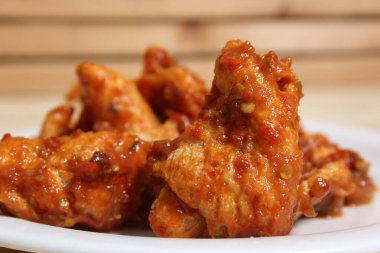 Baharatlı sosla kaplı çıtır tavuk kanadı.