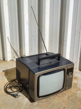 Köy arka planına sahip eski bir kare gri televizyon.