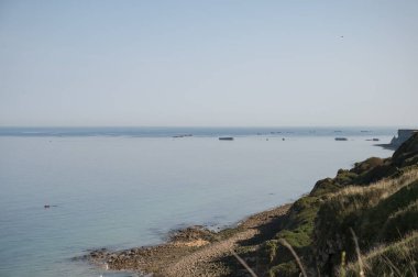 Normandiya 'da manzara Longues Sur Mer. Uzakta geçidi engellemek için denizdeki beton blokları görebilirsiniz.
