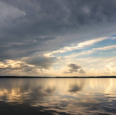 Gün batımında dingin bir gölü gösteren güzel manzara..