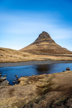 Kirkjufell Mountai, nehir ve mavi gökyüzünün klasik manzarası