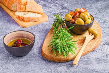 Bitki ve ekmekle servis edilen taze zeytinler.