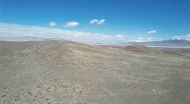 Açık mavi gökyüzünün altında engin bir çöl manzarası