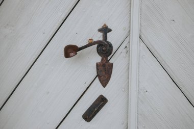 Kürek şeklinde paslı bir kapı kolu.