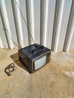 Köy arka planına sahip eski bir kare gri televizyon.