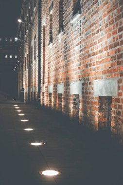 Geceleri Gloucester 'daki tarihi limanlardaki kırmızı tuğla depoları aydınlatılıyor..