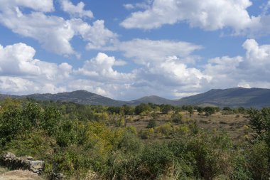 Dağlar ve bulutlardan oluşan manzaralı bir manzara.