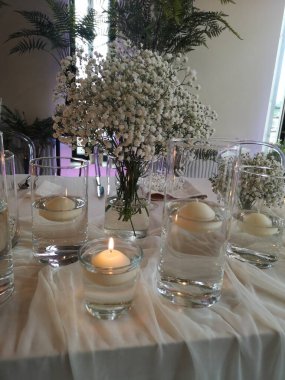 Mumlar ve çiçeklerle dekoratif masa düzenlemesi