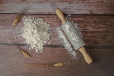 Ahşap bir masa üzerinde merdane ve buğday kulakları ile un yığını ve kopyalama alanı