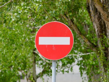 Kırmızı yeşil yapraklarla çevrili giriş işareti yok.