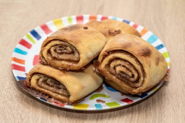 Renkli tabakta taze pişmiş tarçın ruloları.