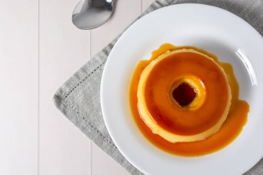 pudim de leite, turta ya da sütlü puding olarak da bilinir, gri kumaşlı beyaz masada.. 