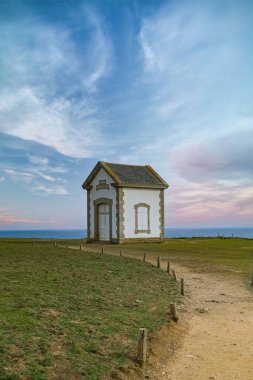 Brittany 'de Belle-Ile, Cote Sauvage' ın kayalıklarında küçük bir bina, sis düdüğü evi.