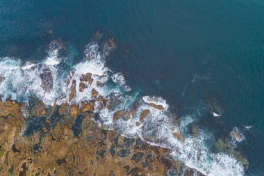 Kayalık kıyıya çarpan okyanus dalgalarının hava aracı görüntüsü