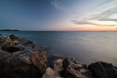 Sakin okyanus dalgaları kayalık kıyılara çarpıyor.