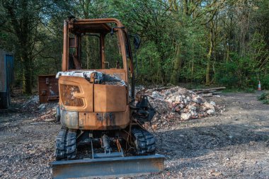 Paslı kazıcı inşaat enkazı yakınına park edilmiş.