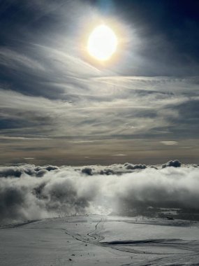 Parlak güneş karlı arazide parlıyor.