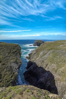 Brittany 'de Belle-Ile, Cote Sauvage' da kayalar ve kayalıklarla kaplı deniz manzarası.