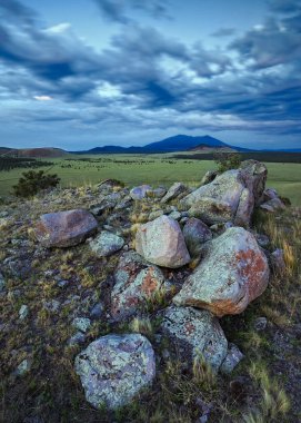 Bulutlu gökyüzünün altındaki kayalık arazi