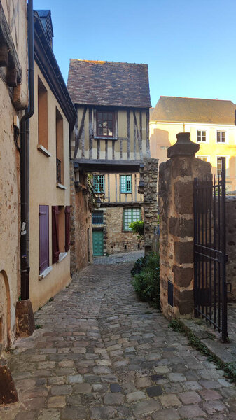 Вертикальное фото живописных переулков старого города Ле-Ман во Франции, висящего дома с плюшевым мишкой в окне