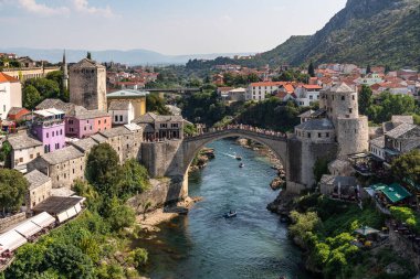 Mostar kentinden akan ve arka planda önemli bir Eski Köprü bulunan nehir, Bosna-Hersek