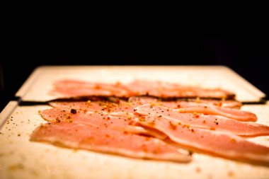 Slices of cured ham on wooden board