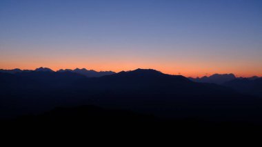 Renkli günbatımına karşı dağların silueti
