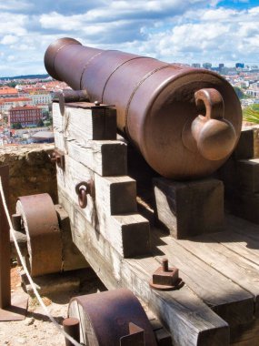 Şehre bakan tahtadan bir arabanın üzerinde duran eski bir top.