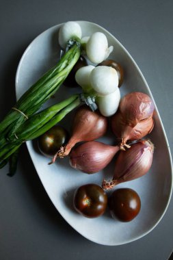 Gri tabakta taze sebzeler.