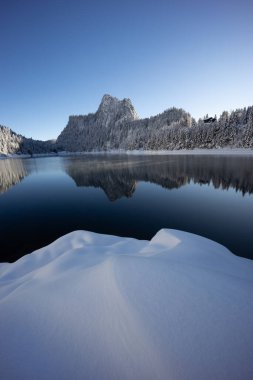 Kış gölü dağlarda yansıma, kar ve ormanla