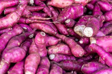 Mor tatlı patatesler üst üste yığılmış.