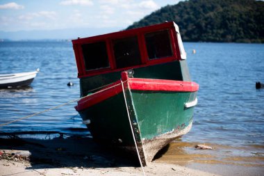 Suyun yakınındaki kumlu sahilde dinlenen renkli tekne