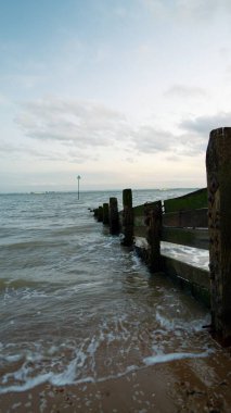 Dalgalar yavaşça tahta direklere çarpıyor.