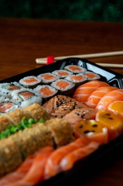 Çeşitli suşi ruloları ve tabakta sashimi.