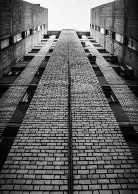 Şehir ortamında dikey hizalanmış tuğla duvarlara sahip yüksek bina.