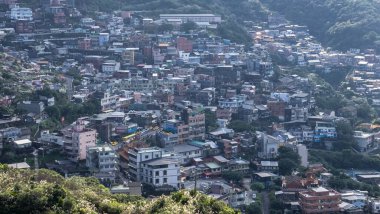 Yamaçta sayısız bina bulunan yoğun nüfuslu kentsel alanın havadan görünüşü