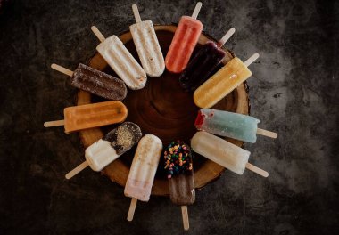 Ahşap tabakta duran renkli dondurmaların yakın çekim düzeni.