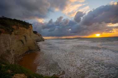 Deniz kıyısında gün doğumu dalgalar ve bulutlarla