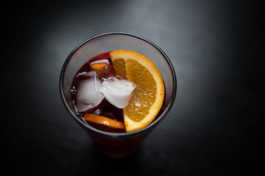 Bir bardak portakal dilimli ferahlatıcı içecek.