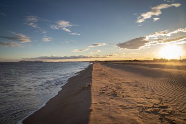 Kumsalda gün batımı ve sakin su