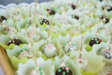 Bardaklara dizilmiş renkli çikolatalı mantarlar.