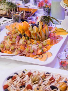 Renkli meyve tabağı ve çeşitli etler.