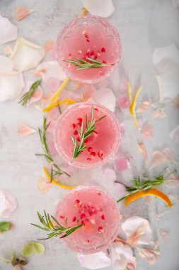Otlarla süslenmiş üç pembe kokteyl.