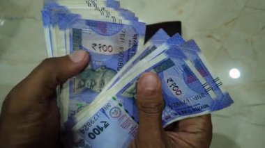 Bir yığın yeni Hint Rupisi Banknotları Sayan Eller