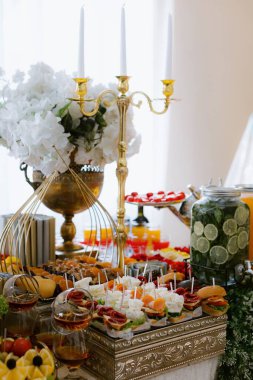 Çeşitli lezzetli ikramlarla dolu zarif bir masa takımı.