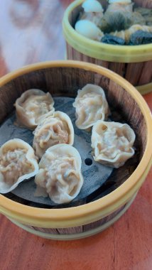 Kalıplı bir yüzeye yerleştirilmiş altı hamur köftesi içeren ahşap bir kase.