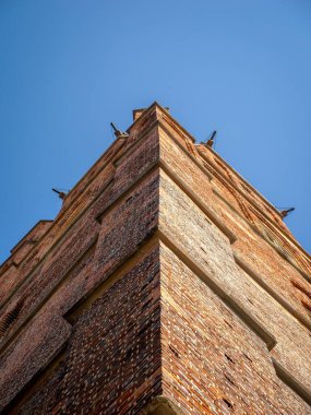 Açık mavi gökyüzüne karşı tuğla bina köşesinin yakın görüntüsü