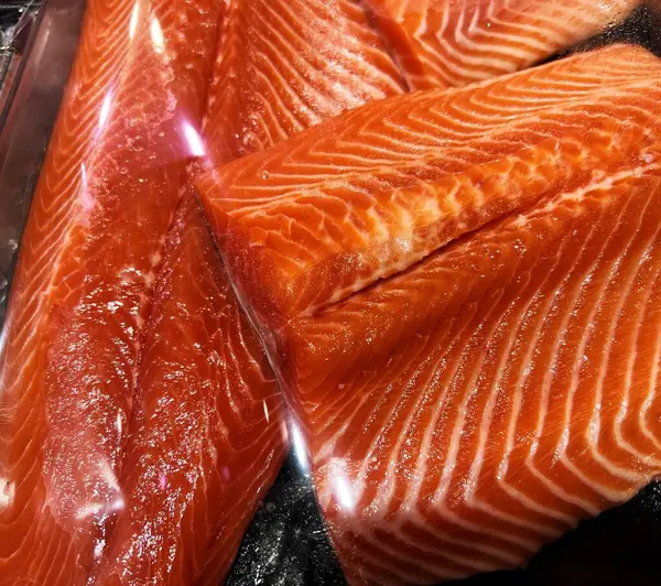 Siyah bir yüzeye sergilenmiş taze somon filetoları..